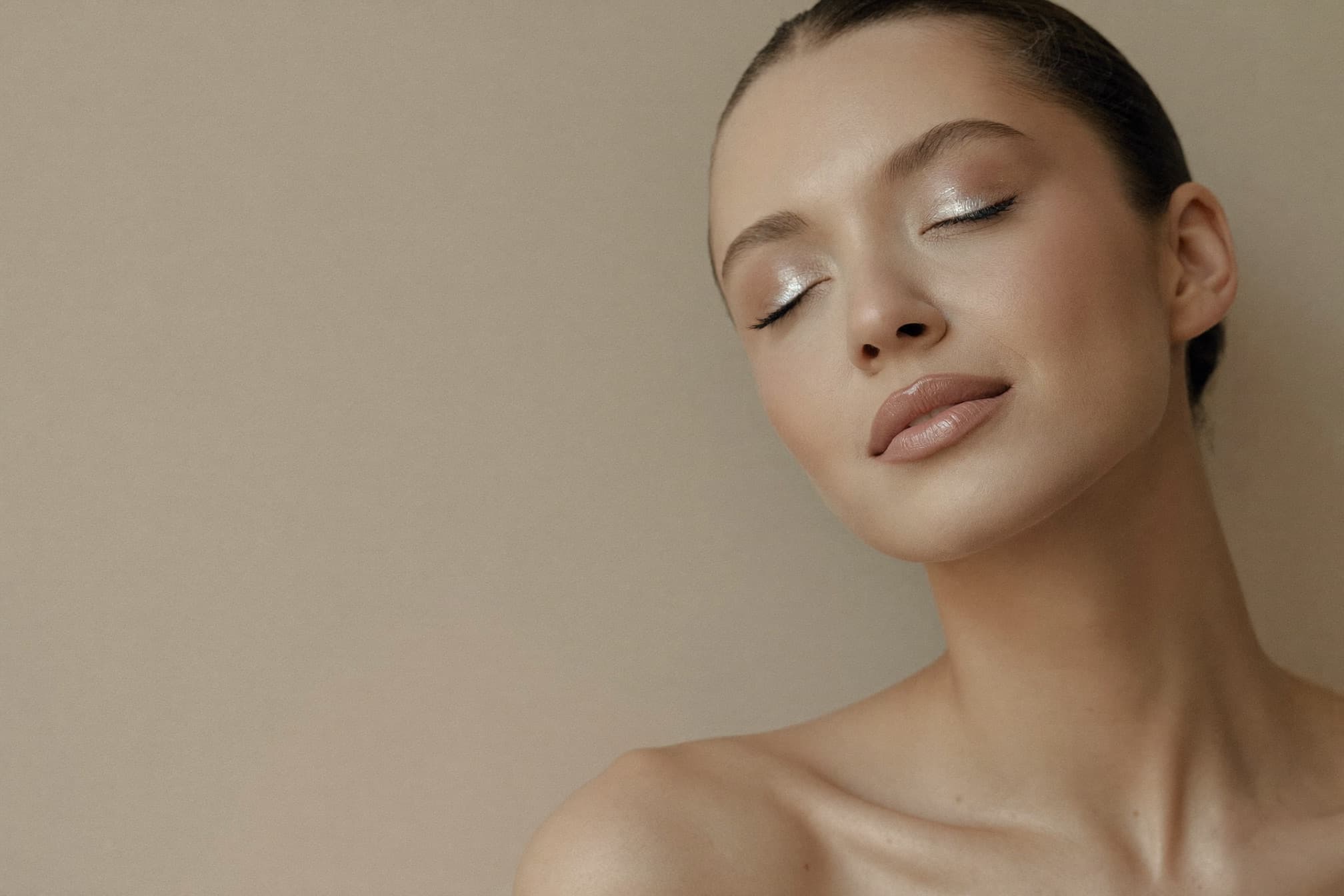 Editorial beauty portrait with luminous champagne-toned makeup